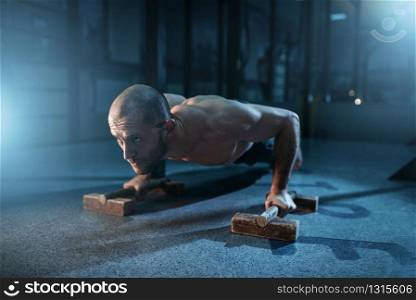Healthy sportsman makes pushups exercises on training. Strong gymnast on workuot