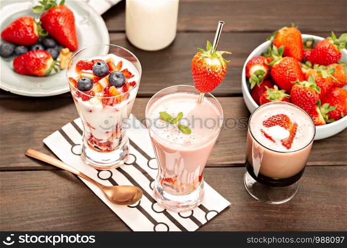 Healthy strawberry smoothie in glass on rustic wood