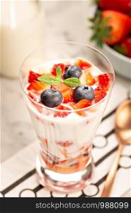 Healthy sweet dessert in glass with strawberries, yogurt and blueberries. Healthy food concept