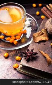 healthy tea with sea-buckthorn. cup with healing tea with sea-buckthorn on wooden retro background
