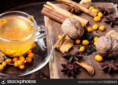 healthy tea with sea-buckthorn. cup with healing tea with sea-buckthorn on wooden retro background