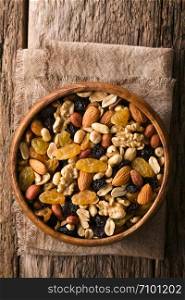 Healthy trail mix snack made of nuts (walnut, almond, peanut) and dried fruits (raisin, sultana) in wooden bowl, photographed overhead (Selective Focus, Focus on the trail mix). Trail Mix Snack of Nuts and Dried Fruits