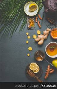 Healthy turmeric spice tea on gray background with teapot, cup of tea and ingredients:  lemon,  ginger, cinnamon sticks and honey , top view.  Immune boosting remedy , detox and dieting concept
