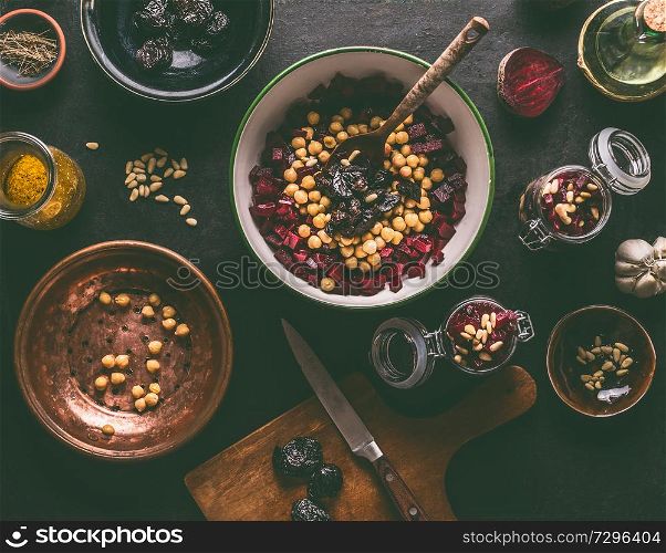 Healthy vegan beetroot salad preparation with chickpeas and pine nuts on dark kitchen table background with ingredients, top view. Purple vegetables eating. Clean dieting food.