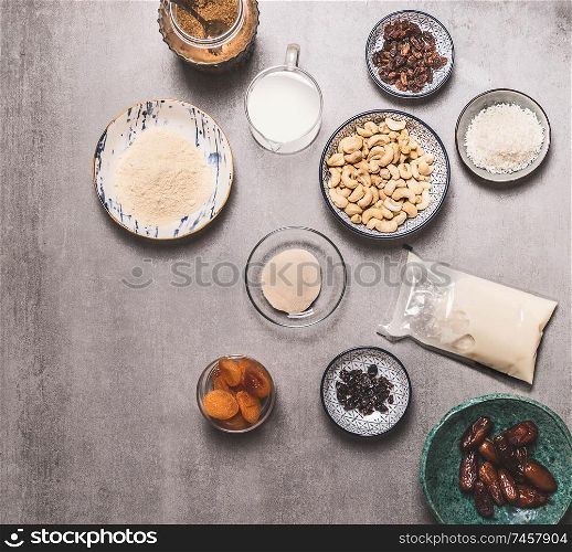 Healthy vegan diet ingredients bowls : cashew , almond flour, Coconut cream, non dairy milk, agar agar, Coconut butter, dried fruits on concrete background, top view. Plant based and Low-calorie diet