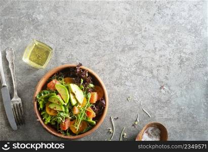 Healthy vegan salad, avocado, cucumber, tomato, radish, nuts and seeds. Girl in denim shirt holding a bowl of vegan salad