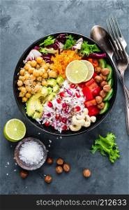 Healthy vegetarian Buddha bowl with fresh vegetable salad, rice, chickpea, avocado, sweet pepper, cucumber, carrot, pomegranate and nuts closeup. Healthy vegetarian Buddha bowl with fresh vegetable salad, rice, chickpea, avocado, sweet pepper, cucumber, carrot, pomegranate and nuts