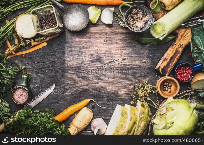 Healthy vegetarian cooking ingredients for soup or stew. Raw organic vegetables with kitchen tools on dark rustic wooden background, top view. Country style