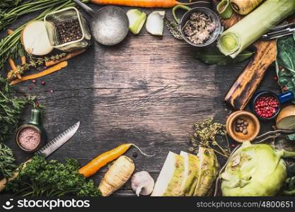 Healthy vegetarian cooking ingredients for soup or stew. Raw organic vegetables with kitchen tools on dark rustic wooden background, top view. Country style