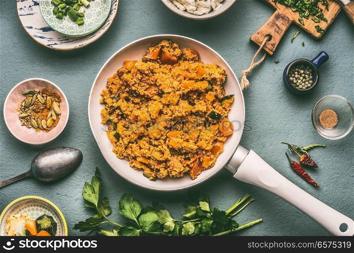 Healthy vegetarian couscous dish with ingredients : vegetables, herbs on dark background, top view, flat lay.