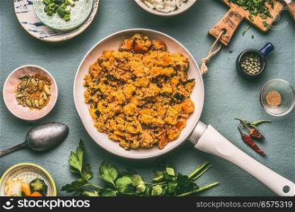 Healthy vegetarian couscous dish with ingredients : vegetables, herbs on dark background, top view, flat lay.