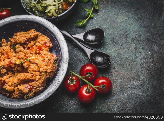 Healthy vegetarian couscous salad in bowl on rustic background, top view, close up, border. Diet eating, Vegetarian or vegan food concept