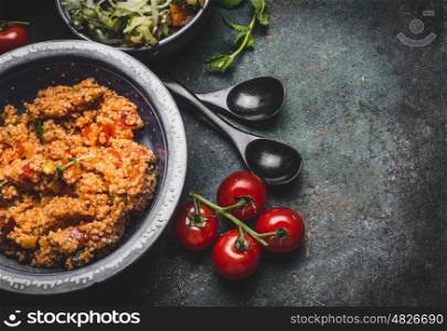 Healthy vegetarian couscous salad in bowl on rustic background, top view, close up, border. Diet eating, Vegetarian or vegan food concept