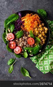 Healthy vegetarian dish with buckwheat and vegetable salad of chickpea, kale, carrot, fresh tomatoes, spinach leaves and pine nuts. Buddha bowl. Balanced food. Delicious detox diet.Top view