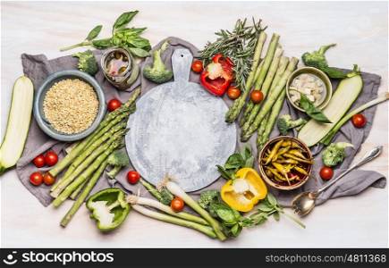 Healthy vegetarian eating with various vegetables and Pearl barley. Porridge or salad ingredients for tasty cooking around round cutting board, top view. Clean eating or diet nutrition concept