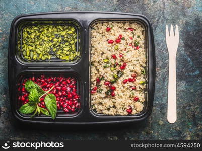 Healthy vegetarian lunch box with quinoa salad with pomegranate and pistachio, top view