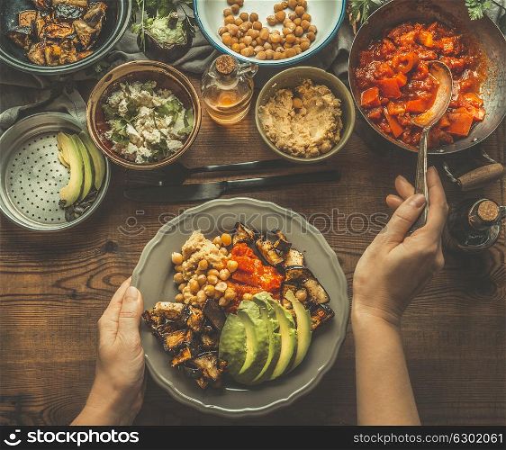 Healthy vegetarian salad bar. Women female hand with spoon puts food on a plate, top view. Healthy lunch. Clean eating or diet food concept