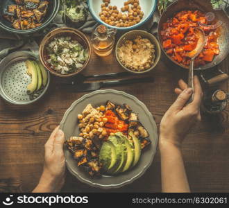 Healthy vegetarian salad bar. Women female hand with spoon puts food on a plate, top view. Healthy lunch. Clean eating or diet food concept