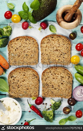 Healthy Vegetarian Sandwiches (with Avocado, Tomato, Cucumber, Onion, Beetroot, Cream Cheese, Herbs and Spices) on blue rustic background