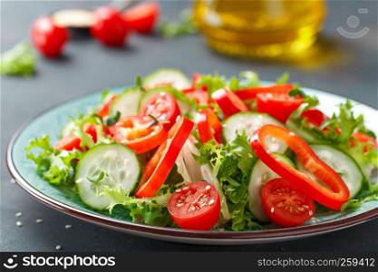 Healthy vegetarian vegetable salad of fresh lettuce, cucumber, sweet pepper and tomatoes. Vegan plant-based food