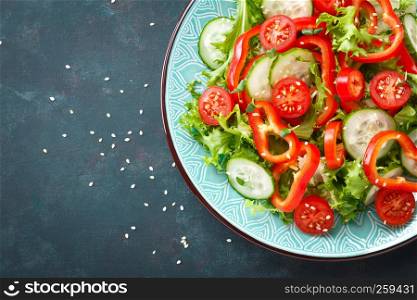 Healthy vegetarian vegetable salad of fresh lettuce, cucumber, sweet pepper and tomatoes. Vegan plant-based food. Flat Lay. Top view