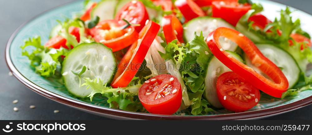 Healthy vegetarian vegetable salad of fresh lettuce, cucumber, sweet pepper and tomatoes. Vegan plant-based food. Banner
