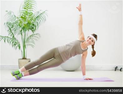 Healthy woman doing gymnastics on floor