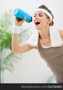 Healthy woman drinking water after workout