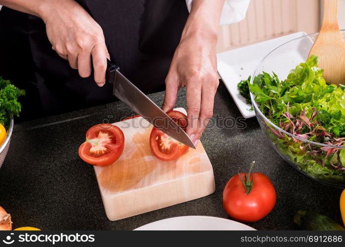 Healthy Woman makes fresh vegetable salad with olive oil, tomato and salad