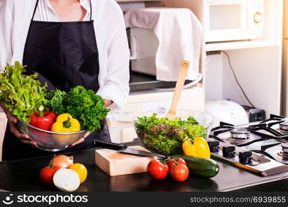 Healthy Woman makes fresh vegetable salad with olive oil, tomato and salad