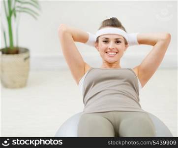 Healthy woman making abdominal crunch on fitness ball
