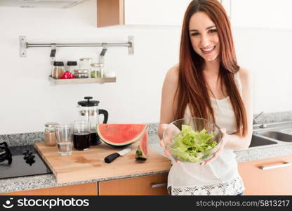 Healthy woman preparing a fresh salad in kitchen