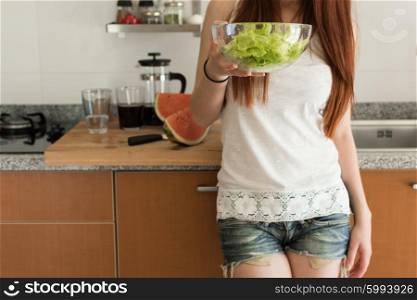 Healthy woman preparing a fresh salad in kitchen