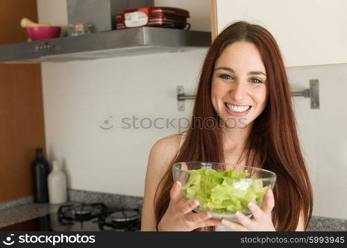 Healthy woman preparing a fresh salad in kitchen