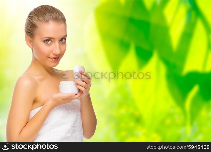 Healthy woman with body cream on floral background
