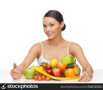 healthy woman with measuring tape and lots of fruits