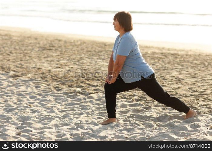 healthy yoga middle ages woman workout yoga pose on mat on the sandy beach at sunrise, benefits of natural environments for physical, spiritual, healthy, relaxing concept.. healthy yoga middle ages woman workout yoga pose on mat on the sandy beach at sunrise, benefits of natural environments for physical, spiritual, healthy, relaxing concept