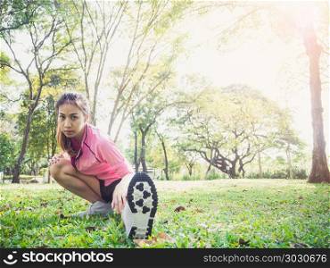 Healthy young asian woman exercising at park. Fit young woman do. Healthy young asian woman exercising at park. Fit young woman doing training workout in morning. Young happy asian woman stretching at the park after a running workout. Exercise outdoor concept.