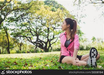 Healthy young asian woman exercising at park. Fit young woman doing training workout in morning. Young happy asian woman stretching at the park after a running workout. Exercise outdoor concept.