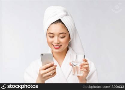 Healthy young beautiful woman drinking water, beauty face natural makeup with holding mobile phone, isolated over white background. Healthy young beautiful woman drinking water, beauty face natural makeup with holding mobile phone, isolated over white background.