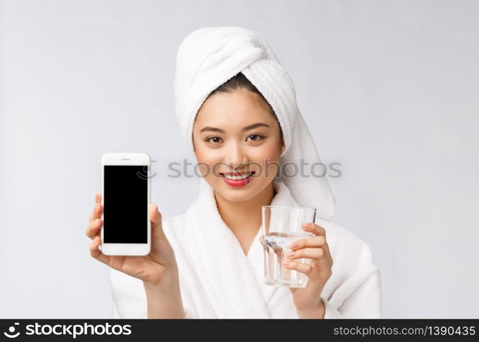 Healthy young beautiful woman drinking water, beauty face natural makeup with holding mobile phone, isolated over white background. Healthy young beautiful woman drinking water, beauty face natural makeup with holding mobile phone, isolated over white background.