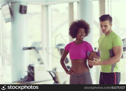 healthy young couple in crossfit gym weights workout with personal trainer. weights workout with personal trainer at crossfit gym