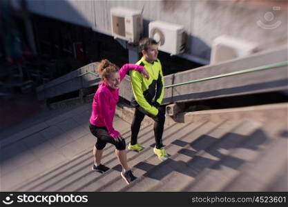 healthy young couple jogging on steps at early morning