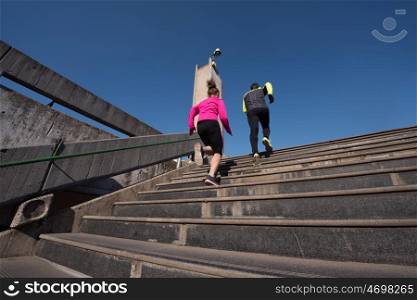 healthy young couple jogging on steps at early morning