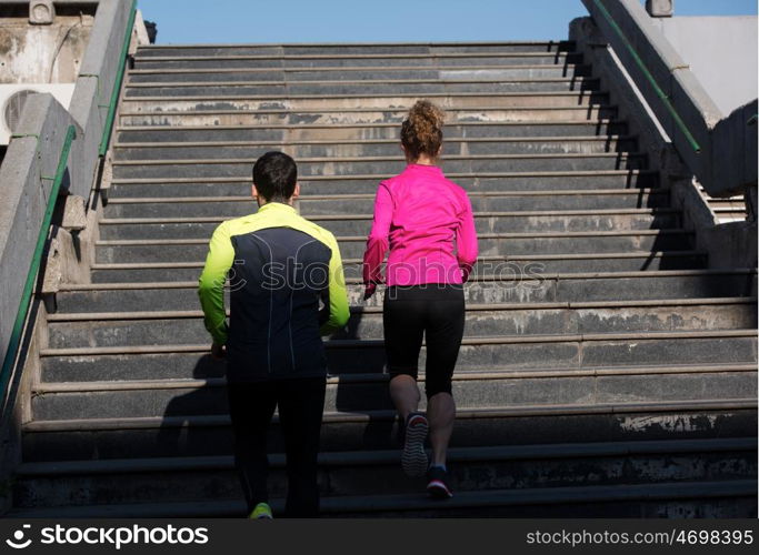 healthy young couple jogging on steps at early morning