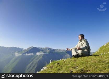 healthy young man practice yoga in height mountain at early morning and sunrise