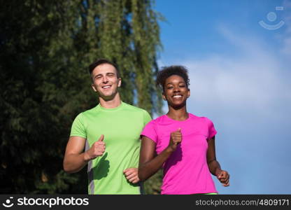 healthy young multiethnic couple jogging in the city on a sunny summer day