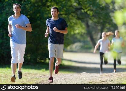 healthy young people running on mountain trail in morning