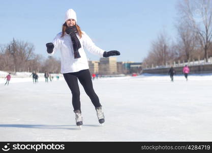 Healthy young woman ice skating during winter