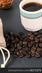 Heap coffe beans and cup of fresh coffee. Heap coffe beans and cup of fresh coffee on dark background